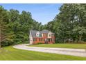 Inviting two-story home with a long driveway and a spacious front yard with mature trees at 4137 Donna Ct, Ellenwood, GA 30294