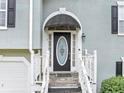 Close-up of home's entrance featuring covered porch, oval glass door, and white trim at 1735 Silver Way, Lithia Springs, GA 30122
