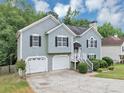 Attractive home with a two-car garage and lush greenery and a well-maintained front lawn at 1735 Silver Way, Lithia Springs, GA 30122