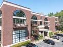 Brick apartment building featuring large arched windows, private balconies, and convenient parking at 790 North Ne Ave # 209, Atlanta, GA 30306