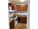 A kitchen featuring wooden cabinets, a white stove and a double sink at 1867 Myrtle Dr # 5, Atlanta, GA 30311