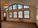 Bright living room featuring large windows, a ceiling fan, and carpet floors at 1046 Sans Souci Way, Clarkston, GA 30021