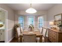 Charming dining area with a wood table, decorative chandelier, and natural light from bay windows at 2047 Cliffton Ter, Snellville, GA 30039