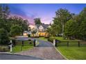 Beautiful home with a circular driveway, manicured lawn, and black fence at 150 Trinity Farm Dr, Canton, GA 30115