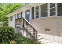 Close up on the home's front entrance, featuring a black door, white trim, and a wooden porch at 1829 Goddard Se St, Atlanta, GA 30315
