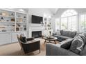 Bright living room with a fireplace, built-in shelving, and large windows providing ample natural light at 1241 Newbridge Trce, Brookhaven, GA 30319