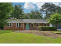 Charming brick home with a well-maintained front lawn and mature trees at 1869 Hebron Hills Dr, Tucker, GA 30084