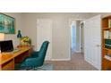 Functional home office featuring a wooden desk, comfortable chair, and built-in shelving for organization at 2247 Cherokee Valley Dr, Lithonia, GA 30058