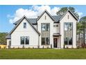 Charming two-story home with white brick, black trim, lush lawn, and professionally landscaped yard at 3735 Tamiami Trl, Cumming, GA 30041