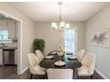 Formal dining room featuring a marble table with seating for six, a stylish chandelier, and access to kitchen at 3110 Ashly Cove Ln, Snellville, GA 30078