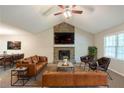 Comfortable living room with a stone fireplace, vaulted ceilings, leather furniture, and a ceiling fan at 3110 Ashly Cove Ln, Snellville, GA 30078