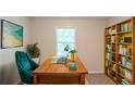 Functional home office with built-in bookshelves, a large wooden desk, and lots of natural light at 3110 Ashly Cove Ln, Snellville, GA 30078