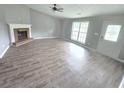 Open-concept living room features a fireplace, large windows, and light wood floors at 563 Fieldgreen Dr, Jonesboro, GA 30238
