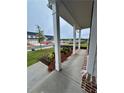 Inviting covered front porch with classic white columns and a view of the landscaped yard at 1654 Tide Mill Rd, Cumming, GA 30040