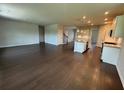Open-concept living room with dark wood floors flowing into a gourmet kitchen with island and stainless appliances at 1654 Tide Mill Rd, Cumming, GA 30040