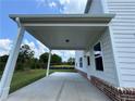 Covered patio with white posts and brick trim, leading to a spacious backyard at 1654 Tide Mill Rd, Cumming, GA 30040