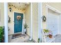 Close-up of a welcoming front door with a wreath, plant, and stylish decor at 183 Venture Path, Hiram, GA 30141
