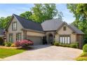 Inviting home with well-maintained lawn, mature trees, an attached garage, and a charming stone and stucco facade at 4569 Fountain Ne Dr, Marietta, GA 30067