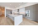 Bright modern kitchen with oversized island, stainless steel appliances, and wood flooring at 2425 Peachtree Rd # 1806, Atlanta, GA 30305