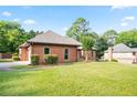Beautiful brick house featuring a lush green lawn and mature trees in a suburban setting at 300 Saddle Creek Ln, Roswell, GA 30076