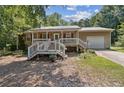 Cozy home with a covered porch, metal roof, attached garage, and a well-maintained front yard at 136 Pine St, Covington, GA 30014