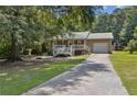 Inviting single-Gathering home with a white-railed porch, metal roof, and attached garage, set on a spacious lot at 136 Pine St, Covington, GA 30014