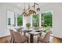 Bright dining room with large windows and contemporary lighting fixture over a table set for six at 32 Walthall Ne St # A, Atlanta, GA 30307