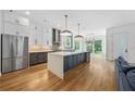 Open concept kitchen with stainless steel appliances, a large island, and stylish pendant lighting at 32 Walthall Ne St # A, Atlanta, GA 30307