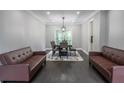 The dining room is lit by a modern light fixture, has sofas, and a dining table at 4569 Campenille Trce, Suwanee, GA 30024