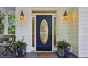 Elegant front door with decorative glass, flanked by potted plants, and stylish sconces, enhancing the entrance at 2177 Mauldin Nw St, Atlanta, GA 30318