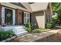 Charming front entrance with brick facade, painted steps, and decorative flowerbeds at 912 Spring Vly, Woodstock, GA 30189