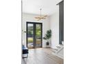 Bright entryway with wood floors, staircase, modern lighting and large black framed glass doors to the exterior at 941 Garibaldi Sw St, Atlanta, GA 30310