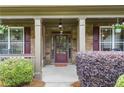 Inviting front porch with brick pillars, hanging plants, and a view of the landscaped yard at 1524 Guthrie Crossing Dr, Loganville, GA 30052