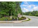 Neighborhood sign with lush landscaping and a glimpse of the surrounding trees and street at 1524 Guthrie Crossing Dr, Loganville, GA 30052