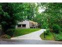 View of the front exterior of the home with an extra long drive way and beautiful mature trees at 3402 Wynnewood Ln, Duluth, GA 30096