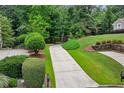 Long driveway leading to the house, surrounded by mature trees and meticulously maintained landscaping and green grass at 770 Spalding Heights Dr, Atlanta, GA 30350