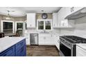 Bright kitchen featuring stainless steel appliances, white cabinets, and a blue kitchen island at 140 Ashewoode Downs Ln, Johns Creek, GA 30005