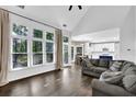 Open-concept living area with large windows, hardwood floors, and a seamless transition to the kitchen at 140 Ashewoode Downs Ln, Johns Creek, GA 30005