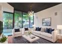 Bright living room with a modern chandelier, white furniture, and large windows at 855 Peachtree Ne St # 1108, Atlanta, GA 30308