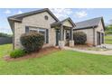 Inviting brick home featuring manicured bushes, a two-car garage, and a secure ADT security system at 80 Pulaski Pl, Jonesboro, GA 30238