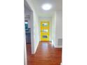 Bright hallway with hardwood floors and a modern yellow door, illuminated by a skylight at 144 Morning Creek Rd, Jonesboro, GA 30238