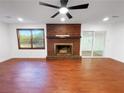 Open-concept living room with a cozy brick fireplace and modern ceiling fan at 144 Morning Creek Rd, Jonesboro, GA 30238