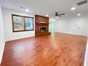 Spacious living room featuring a brick fireplace, sleek hardwood floors, and ample natural light at 144 Morning Creek Rd, Jonesboro, GA 30238