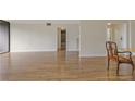 Open-concept living area boasts wood floors and a view into the dining room and hallway at 3530 Piedmont Ne Rd # K8, Atlanta, GA 30305
