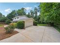 Exterior view of home featuring a side-entry garage, and lush landscaping at 4984 Wickford Way, Atlanta, GA 30338