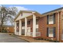 Angle shot of a brick apartment with white columns and black shutters, set in a quiet, tree-lined neighborhood at 135 E Hill St # 24, Decatur, GA 30030
