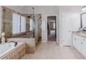 Bathroom features a tile shower, soaking tub, double vanity, and large window providing natural light at 200 Long Needle Ct, Sugar Hill, GA 30518