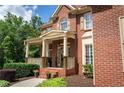 Close-up of the brick facade and cozy porch, enhanced by manicured landscaping at 200 Long Needle Ct, Sugar Hill, GA 30518
