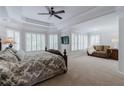 Spacious main bedroom features a sitting area, tray ceilings, a ceiling fan, and lots of natural light at 200 Long Needle Ct, Sugar Hill, GA 30518