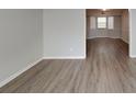 Open-concept space with gray walls, light vinyl flooring and large picture window to the next room at 3637 Chinaberry Ln, Snellville, GA 30039